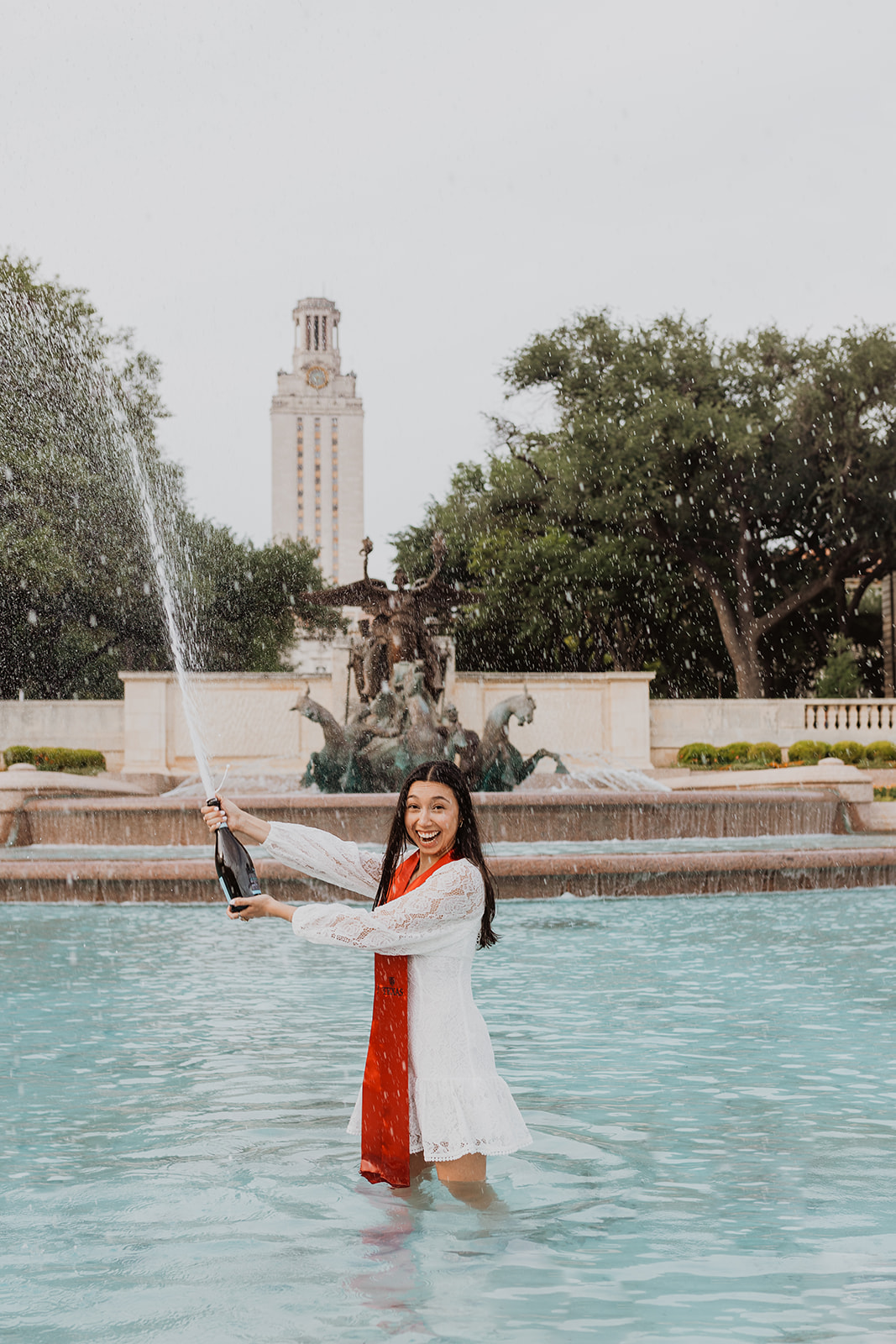 ut austin senior inside littlefield fountain popping champagne