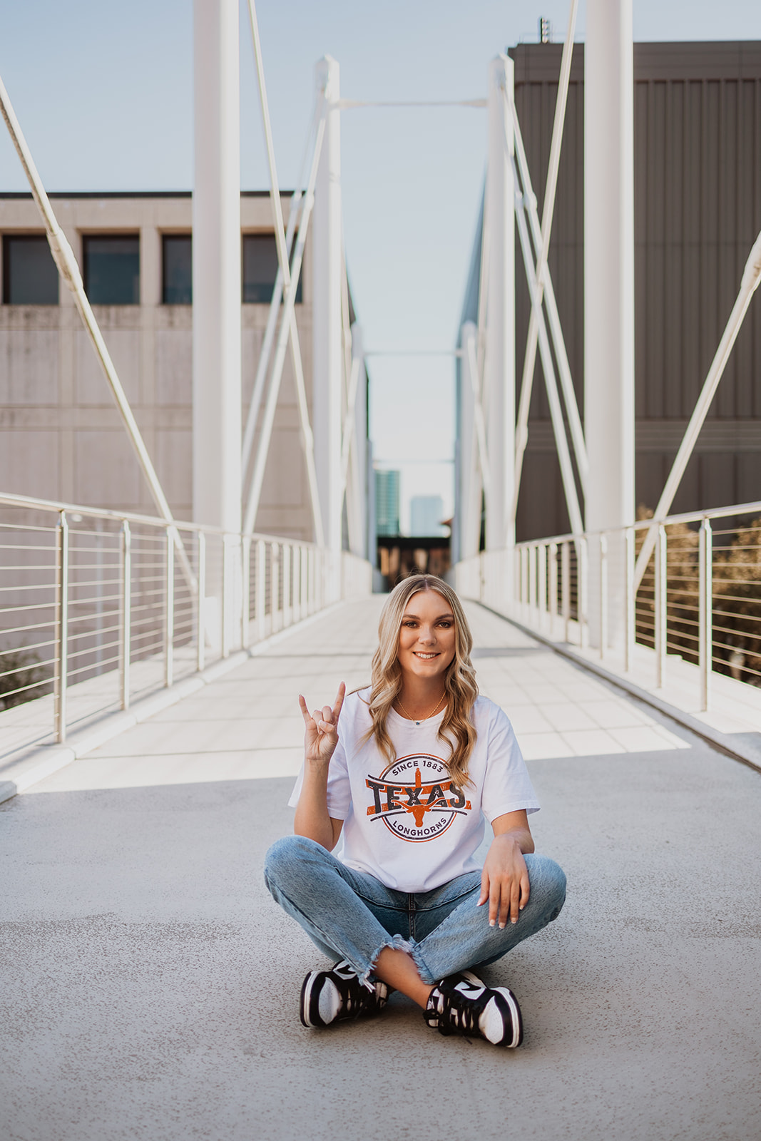 UT Austin grad sits on the Moody College of Communication bridge